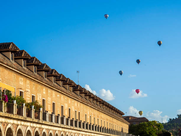 Igualada, spain - july 8, 2023: hot air balloon floating over rugged montserrat mountain landscape, revealing scenic catalonian terrain near igualada, spain