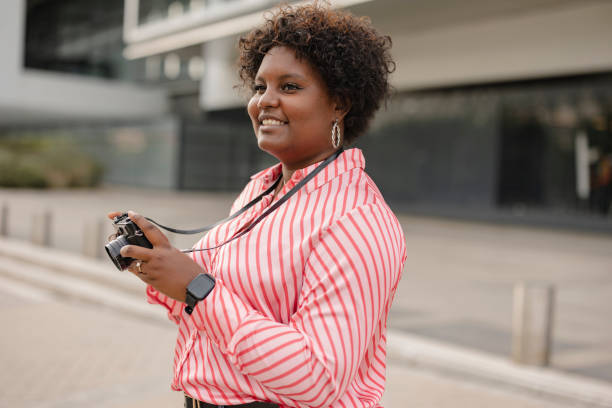istock Smiling young afro woman with retro photo camera 1436455876