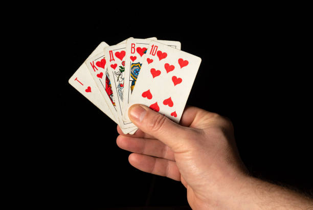 istock Close up male hand holding Royal Flush cards while playing poker 1436457566