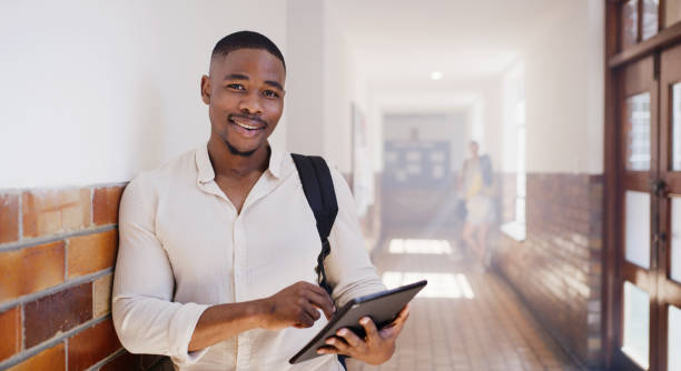istock College student, man and digital tablet education in campus hallway, school building and university. Portrait black guy learning, studying and reading online ebook research of academic exam knowledge 1436459441