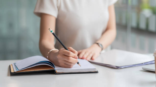 istock Image of a businesswoman holding a pen and taking notes on work concept. 1436462765