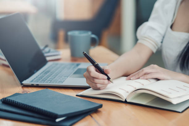 istock Image of a businesswoman holding a pen and taking notes on work concept. 1436462805