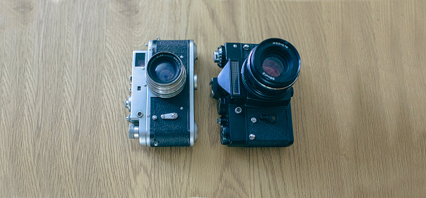 Photograph of two vintage photo camera models on a display shelf
