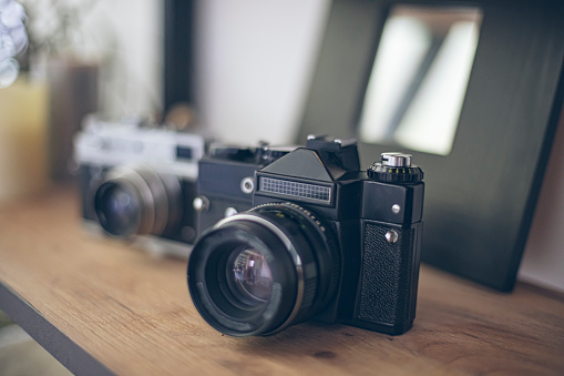 Photograph of two vintage photo camera models on a display shelf