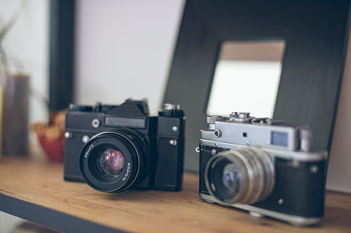 Photograph of two vintage photo camera models on a display shelf