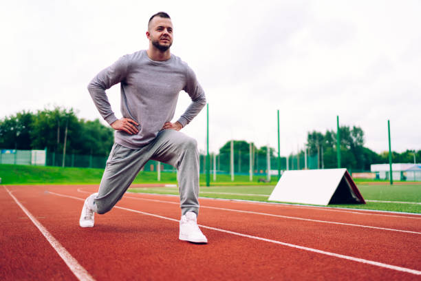istock Confident sportsman stretching on track 1436464945