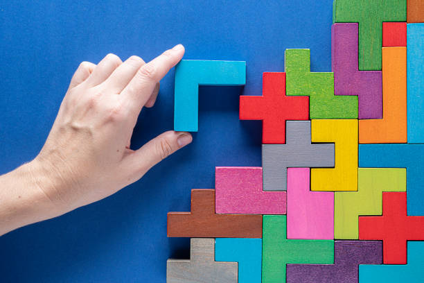 istock Concept of decision making process. Logical tasks. Hand holding wooden puzzle element. Hand sets the element of the puzzle. 1436467160