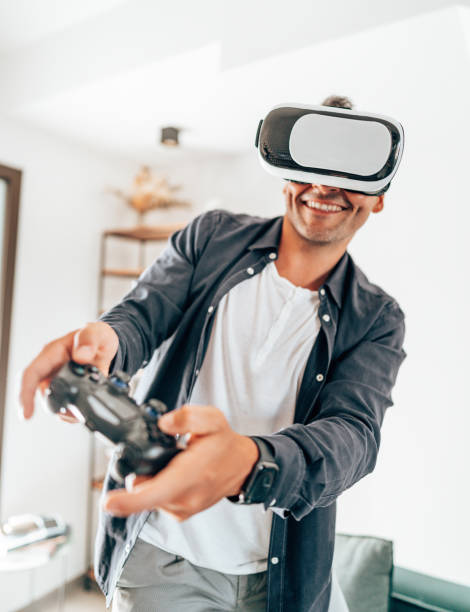 young man smiling using VR simulator stock photo