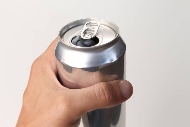 istock Person holding an open aluminum can on white background. 1436472420
