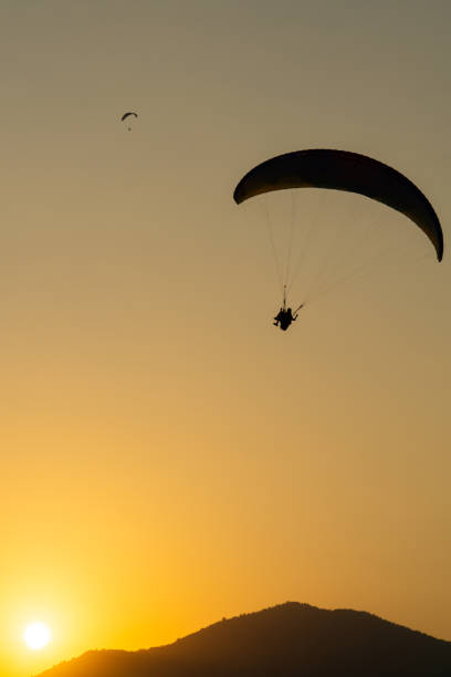 istock Parachutist flying in the sky at sunset 1436473771