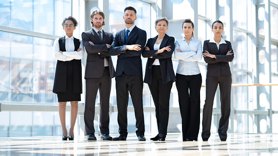Team portrait of successful business people looking at camera standing in office building