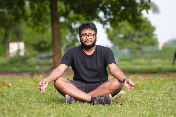 istock Young man practices yoga and meditation at park 1436481848