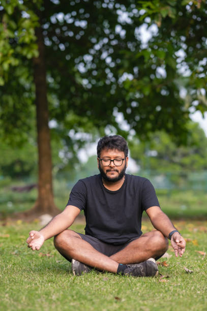 istock Young man practices yoga and meditation at park 1436481854