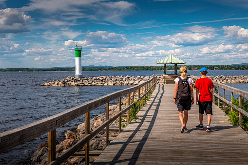 people walking on a pier with a lighthouse in Canada