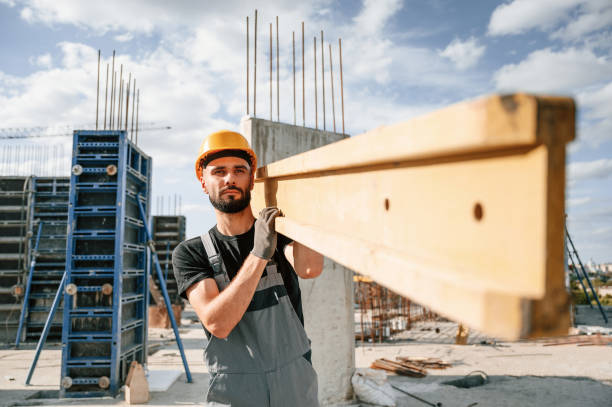 istock Carrying wooden plank. Man in uniform is working on the construction site 1436483375