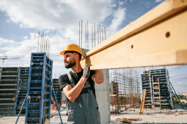 istock Carrying wooden plank. Man in uniform is working on the construction site 1436483633
