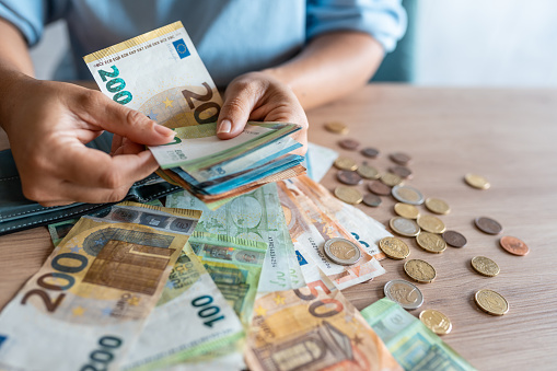 Stack of coins on euro banknotes as wide panoramic format, website header concept for business, finance or inflation, copy space, selected focus, narrow depth of field