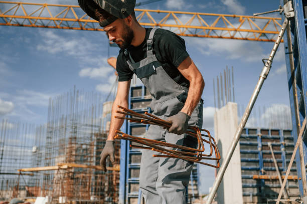 istock Working with rusty metal pieces. Man in uniform is on the construction site 1436484110