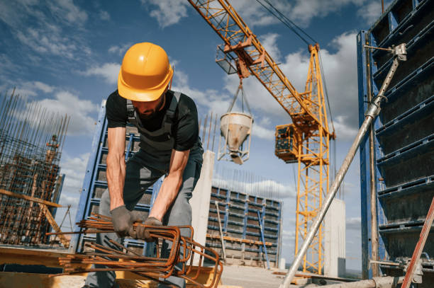 istock Metal pieces covered in rust. Man in uniform is working on the construction site 1436484167