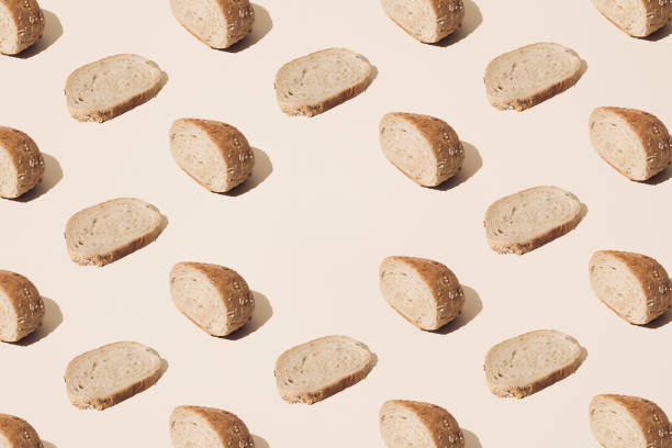 istock Slices of bread on a cream background. Pattern with copy space. 1436484178