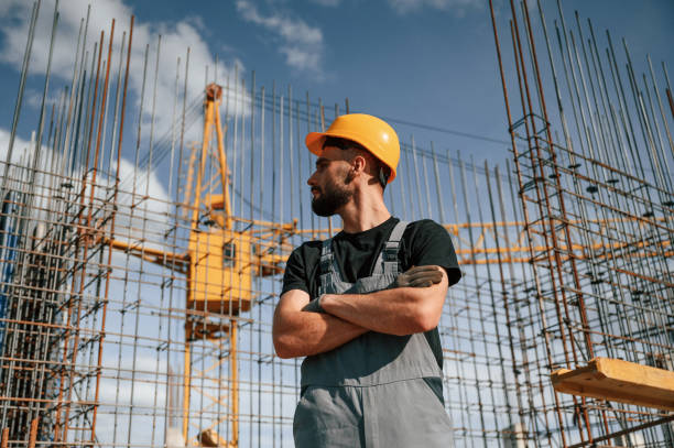 istock Standing against the crane with arms crossed. Man in uniform is working on the construction site 1436484681