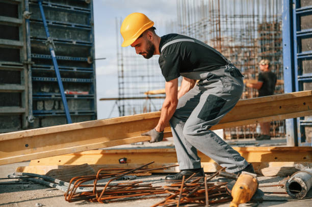 istock Placing wooden plank on the floor. Man in uniform is working on the construction site 1436485295