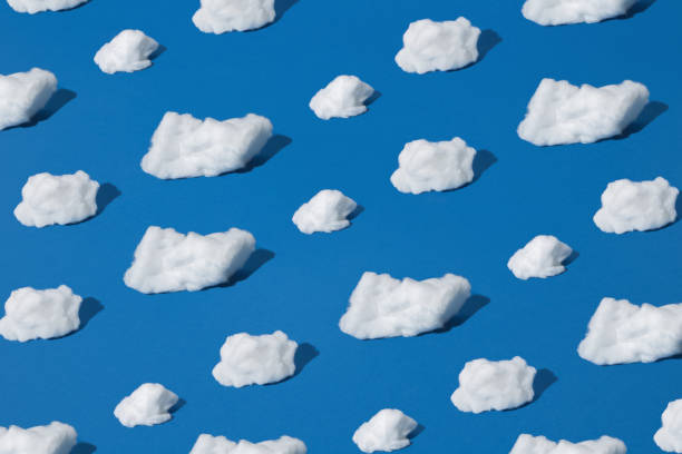 istock Different shapes of white cotton wool clouds on a blue background. Pattern. 1436485434