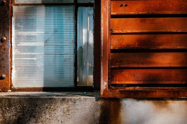 istock Dirty industrial window with rusted metal shutter and concrete. 1436494033