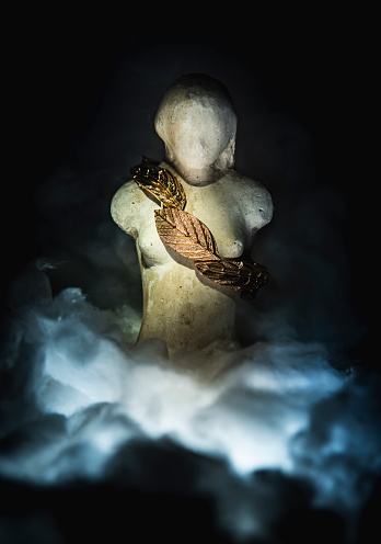 Image of a golden bracelet on the figure of a woman in the clouds