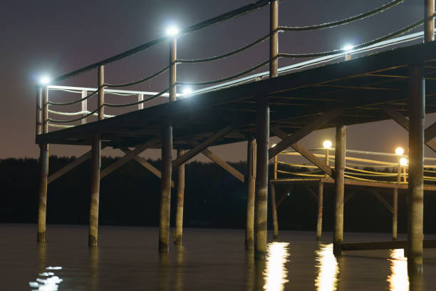 Photography of water reservoir landscape. Mysterious dark night in the Russian countryside. Empty pier. Concept of the beauty in nature and domestic Russian tourism. Holidays theme. Long exposure