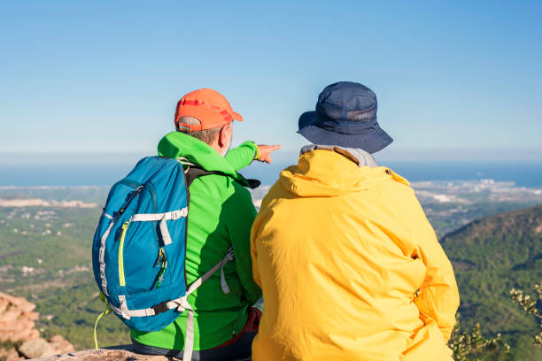 istock Two hikers relax on top of a mountain with a great view 1436497841