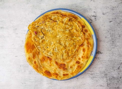anda paratha or omelet paratha served in a plate isolated on background top view of indian and pakistani desi food