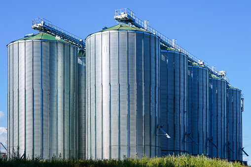 Storage tanks in food and drink distribution industry, sunny, clear blue sky background. Galicia, Spain.