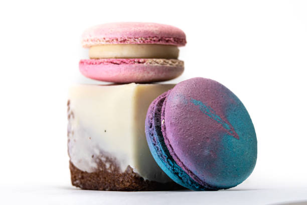 deliziosi macarons francesi colorati, con un pezzo di torta, su uno sfondo bianco - biscotti cookie chocolate pistachio foto e immagini stock