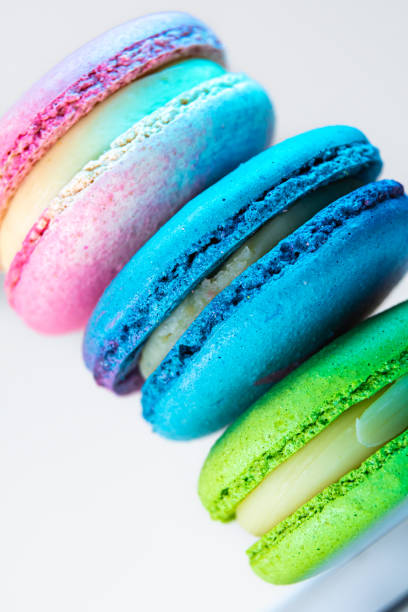 deliziosi macarons francesi colorati su uno sfondo bianco - biscotti cookie chocolate pistachio foto e immagini stock