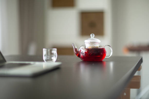 Fresh tea flowing to a tea cup from a teapot