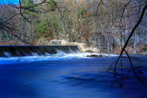 Long exposure photography of Blackstone River flowing over the Albion Dam spillway, Lincoln, Rhode Island, USA.
