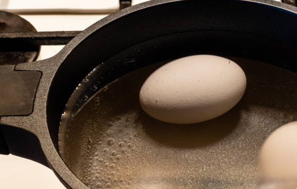 istock White chicken egg with bubbles of boiling water 1436503516