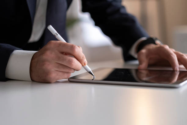 istock Businessman Signing Digital Contract On Tablet Using Stylus Pen 1436503672