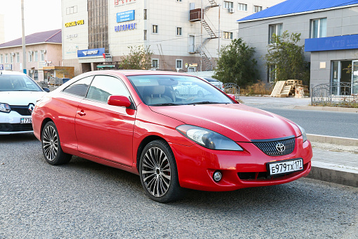 Atyrau, Kazakhstan - October 19, 2022: Red coupe car Toyota Camry Solara in the city street.