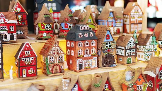 Old houses set stand on a shelf. Medieval European colorful houses made of ceramics. Souvenirs at the Christmas market. Old town street toys.