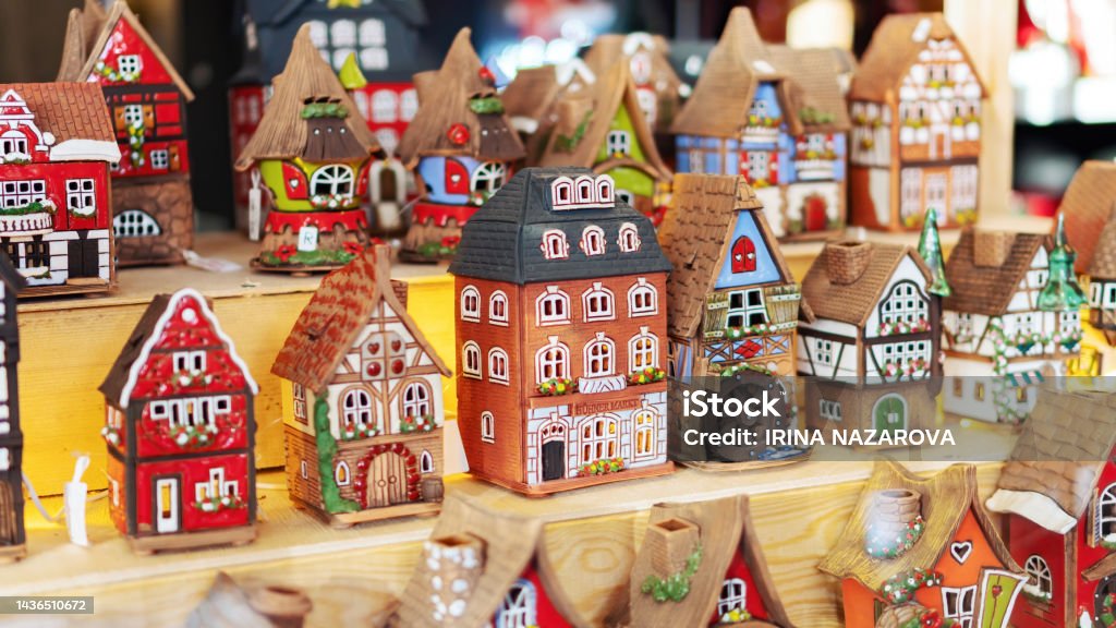 Old houses set stand on a shelf. Medieval European colorful houses made of ceramics. Souvenirs at the Christmas market. Old town street toys. Porcelain Stock Photo