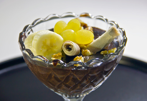 chocolate pudding with banana and grapes in a cup