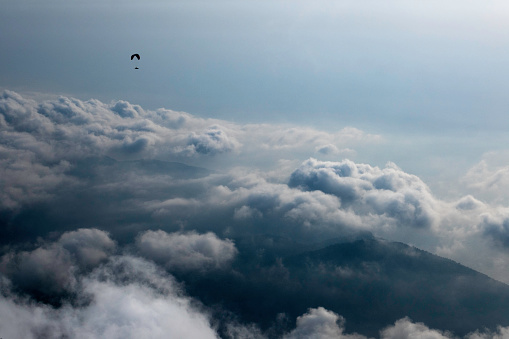 Paraglider at high over the clouds