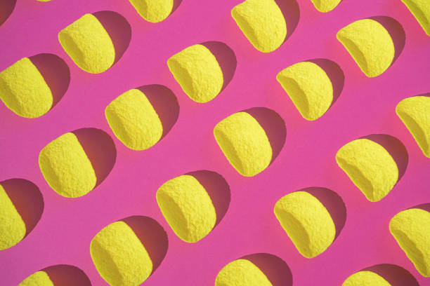 Potato chips seamless pattern on a vibrant pink color background. Flat lay, top view.