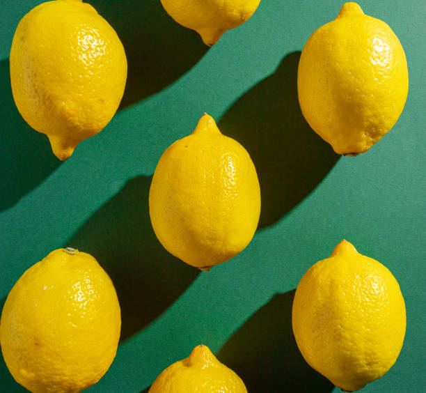 istock Lemons on a green background lit by strong side light with dark shadows. Vitamins, citrus, fruits, autumn, immunity, cold protection. 1436517481