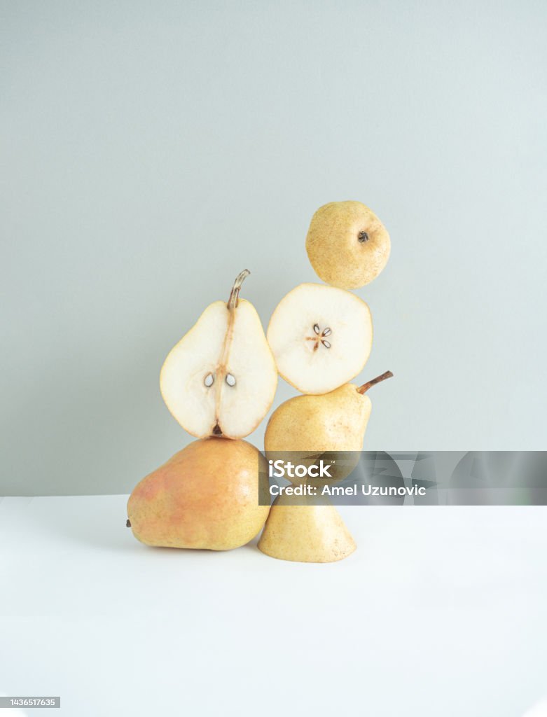Autumn fruit. Creative still life composition. Pear and pear slices on a white and grey background. Chopped Food Stock Photo