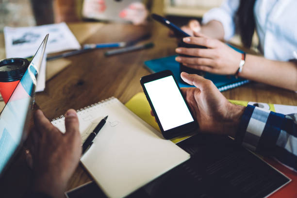 istock Anonymous man surfing cellphone during teamwork with colleagues 1436518467