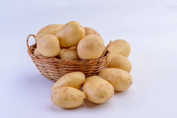 istock Potatoes inside straw basket isolated on white background. 1436520144