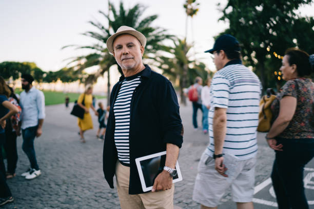 istock Positive mature man with tablet walking around city 1436521290